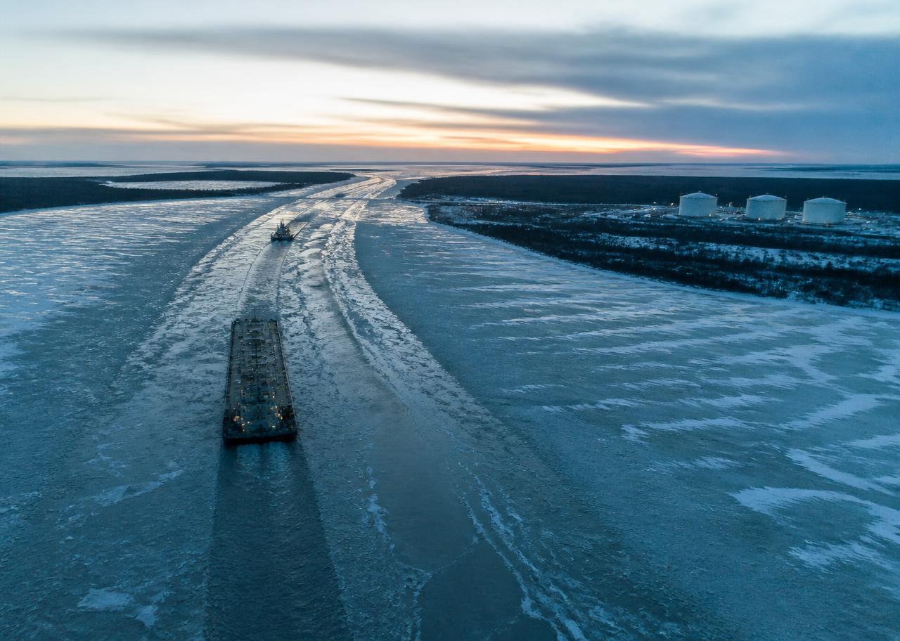 Fuel barge cutting through ice toward a remote tank farm